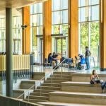 Students sitting in a windowed-building.