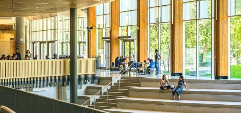 Students sitting in a windowed-building.