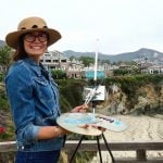 Girl holding a paintbrush and plate while standing at Montage Resort in the background.