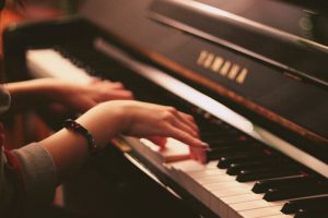 Close up of a girl's hands playing piano.