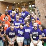 Smiling alumni wearing violet and orange shirts that say "Campus Pride".