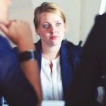 A business woman facing two other business women.