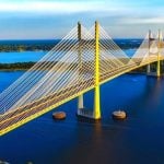 A yellow bridge going across water.