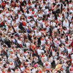 A crowd of people all wearing white and red.
