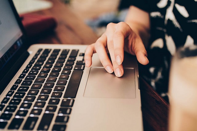 Close up hands scrolling laptop touchpad.