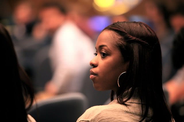 A woman looking to the left over her shoulder.