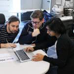 Three people having a meeting while looking at the laptop.