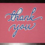 Thank you cursive font against pink background.