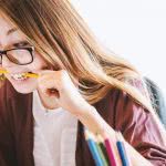 A student biting onto a pencil looking frustrated.