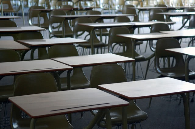 An empty classroom filled with desks and chairs.
