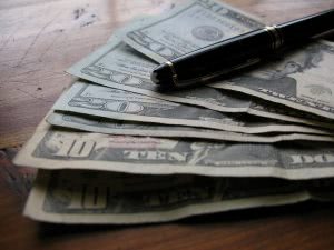 Black ballpen on the top of 6 dollar paper bill compiled.