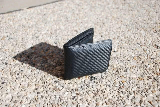 A black wallet on the ground.