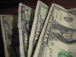 Four dollar bills stacked on each other.