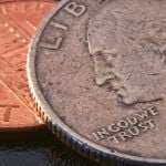 A quarter laying on top of a penny.