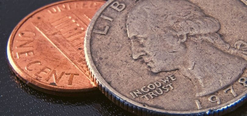 A quarter laying on top of a penny.