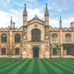 A college building with a mowed lawn in front of it.