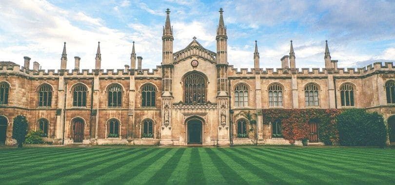 A college building with a mowed lawn in front of it.