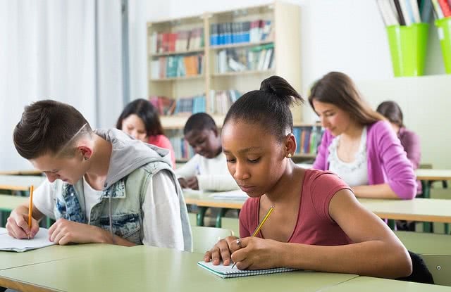 Students are writing on their desks.