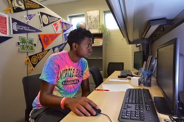 Male student seriously working on his computer.