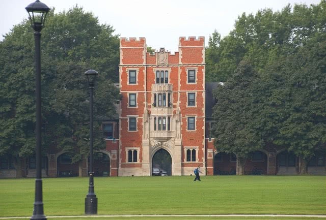 A student walking in Rawson Hall at Grinnell College campus.