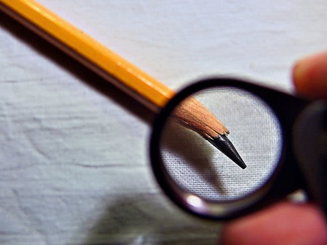 Yellow pencil with a broken tip on a blank sheet.