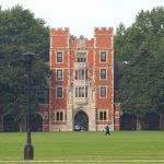 A student walking in Rawson Hall at Grinnell College campus.