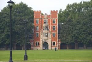 A student walking in Rawson Hall at Grinnell College campus.