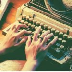 A person typing on a typewriter.