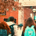Students wearing backpacks walking on campus.