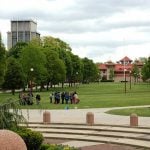 Students gathering in The Queens College campus field.