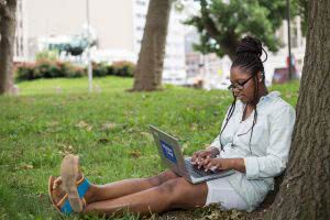 A student writes her college app essay on her laptop