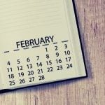 A high school student's calendar planner sitting on a wooden desk.