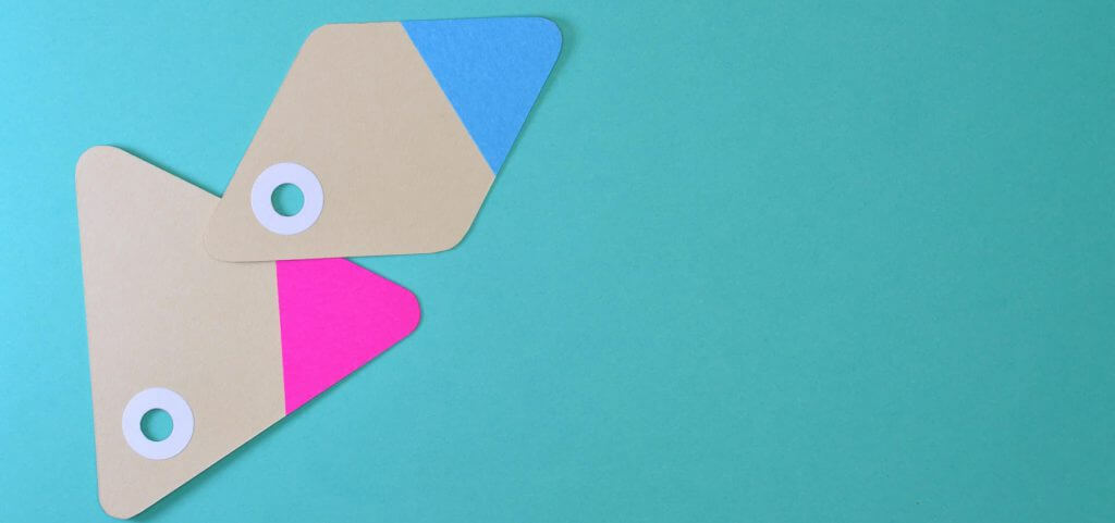 Two beige tags with pink and blue corners against a blue background.