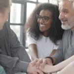 A group of people putting their hands together.