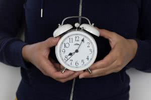 A student holding an alarm clock.