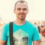 A college student on campus smiling at a camera.