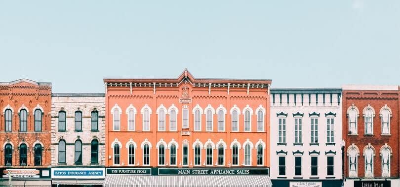 Colorful buildings in a row in front of a blue sky.