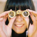 Woman holding binoculars - how do scholarships work? we can help you search