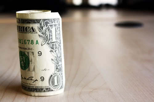 Rolled dollar bill - save money on the cost of college education