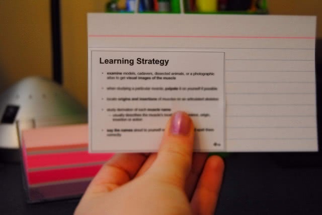 Student holds up her flashcard as she studies for the SAT test