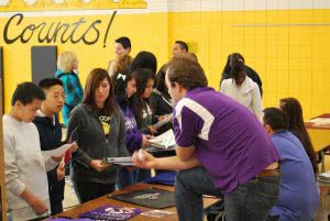 Students attending a college fair, asking themselves where should I go to college?