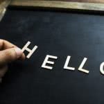 A student holding the letter H, spelling out "hello."