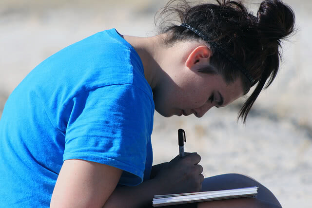 A student working on their scholarship essay. Avoid these cliches when you write yours