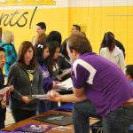 Students attending a college fair, asking themselves where should I go to college?