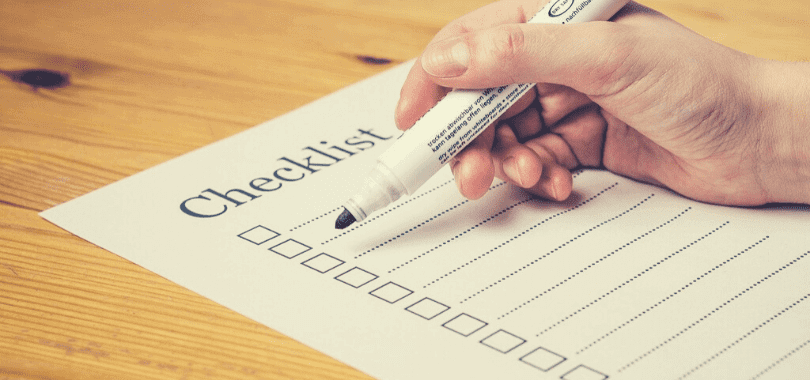 A person holding a marker against a checklist.