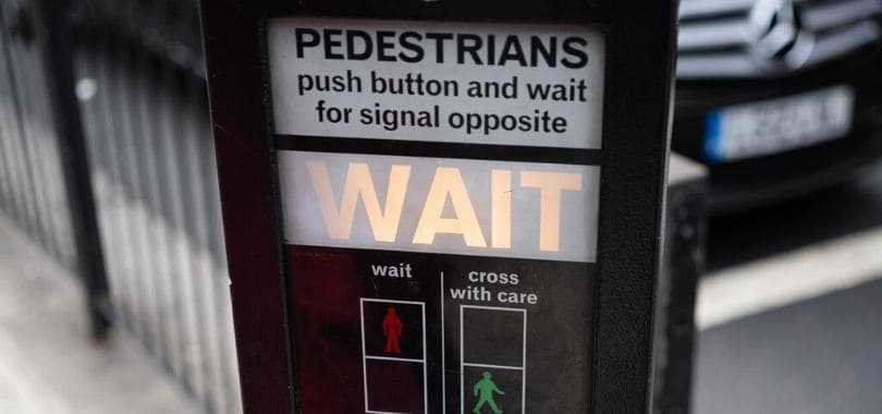 A pedestrian crossing button that says 