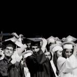 High school students at graduation, moving their tassels on their graduation caps.