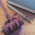 Gavel and two law books on wooden table.