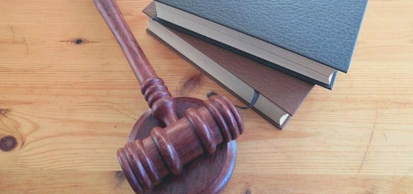 Gavel and two law books on wooden table.