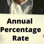 A man in a suit holding up a sign that says "Annual Percentage Rate"